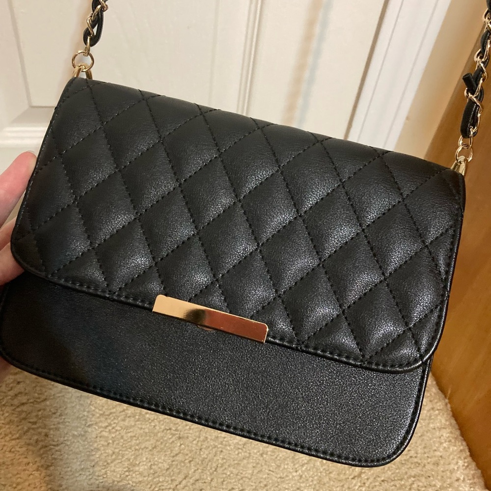 Black quilted cross body purse with gold chair detail and patchwork stitching